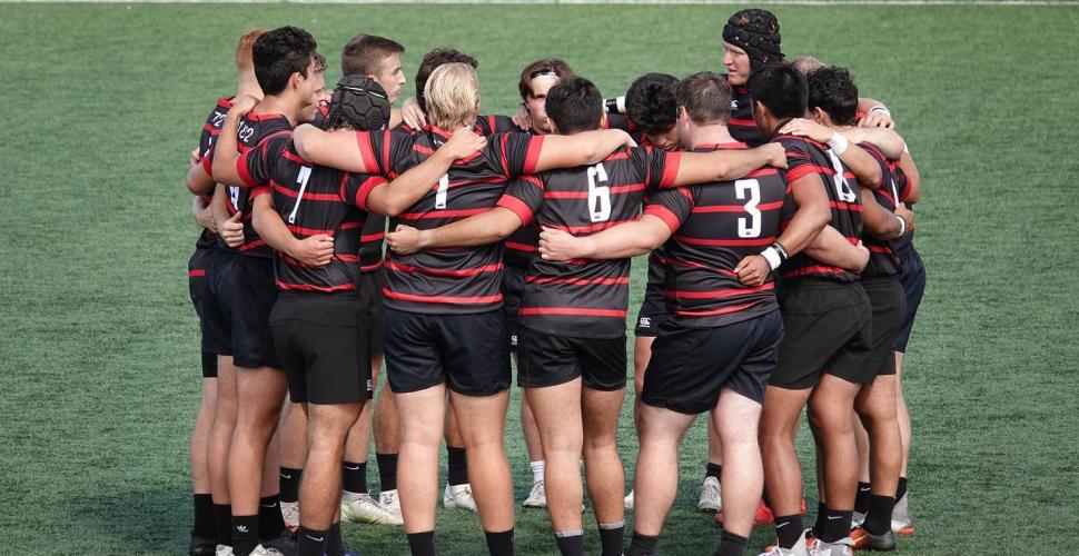 men's team huddles on the field